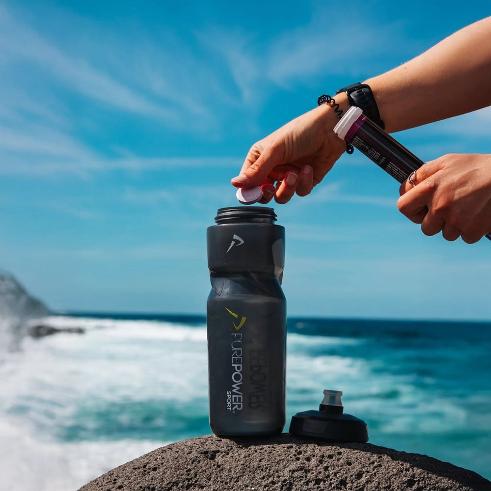 Atlet drikker PurePower Hydro Jordbær/Lime under træning på stranden